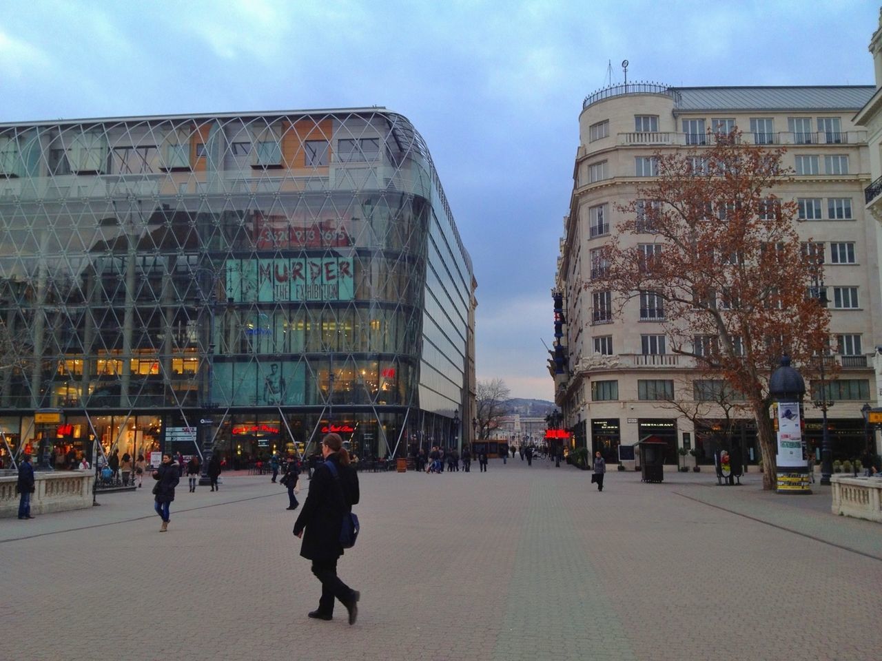 architecture, building exterior, built structure, city, street, large group of people, men, city life, sky, person, walking, lifestyles, text, transportation, road, city street, building, outdoors, incidental people