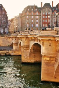 Bridge over river in city against sky