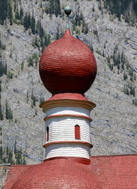 Low angle view of st bartholomew church against mountains on sunny day