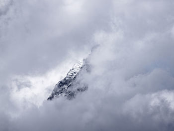 Low angle view of snow covered mountain against sky