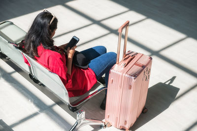 Rear view of woman sitting at airport