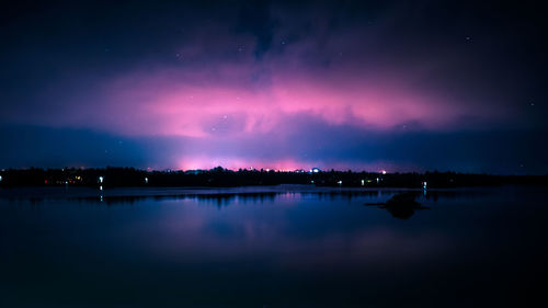 Scenic view of lake against sky at night