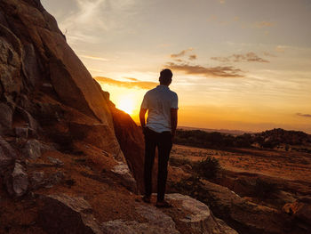 Rear view of man standing on rock