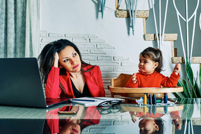Portrait of happy woman sitting on table at home