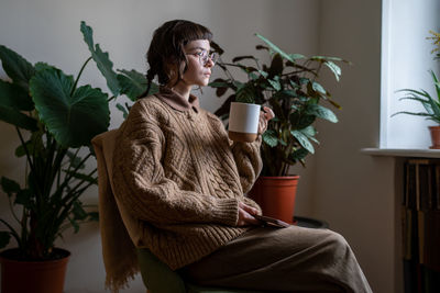 Young woman sitting on sofa at home