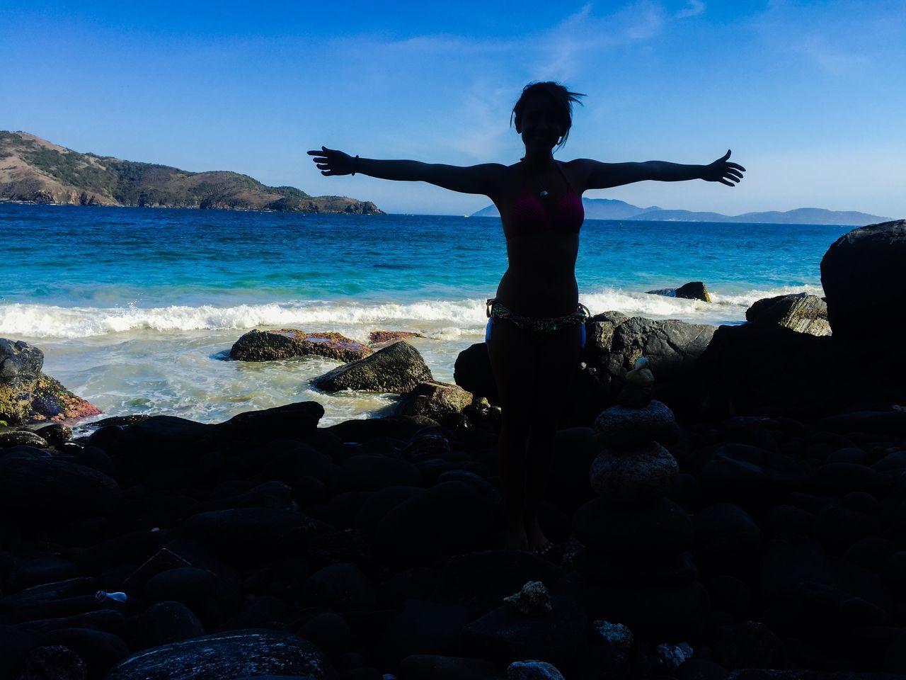 sea, water, horizon over water, rock - object, leisure activity, sky, scenics, full length, lifestyles, standing, tranquility, tranquil scene, beauty in nature, shore, beach, nature, silhouette, idyllic