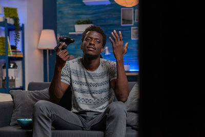 Young man sitting on sofa at home