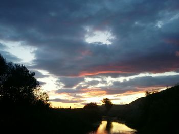 Scenic view of dramatic sky over silhouette landscape