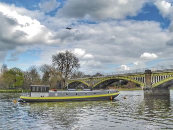 Boat sailing towards arch bridge over river