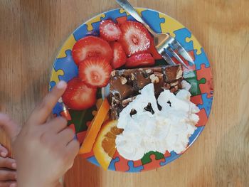 High angle view of hand holding ice cream on table