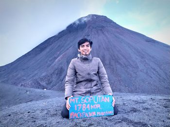 Portrait of young man against mountain against sky