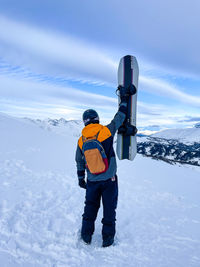 Rear view of man skiing on snow covered landscape