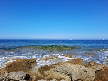 Scenic view of sea against clear blue sky