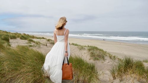 Woman at beach against sky