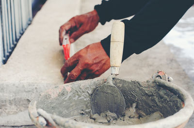 Midsection of man working on barbecue grill