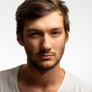 Close-up portrait of young man against white background