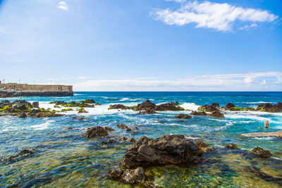 Rock formations in sea against sky