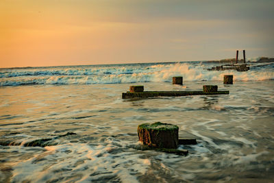 Lifeguard hut on beach against sky during sunset