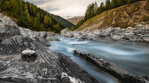 Scenic view of river amidst mountains against sky