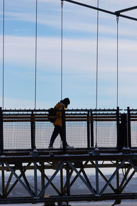 Full length of woman walking on bridge during winter