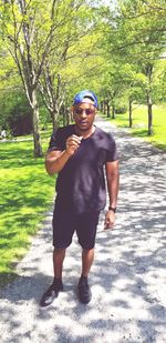 Portrait of young man standing against trees