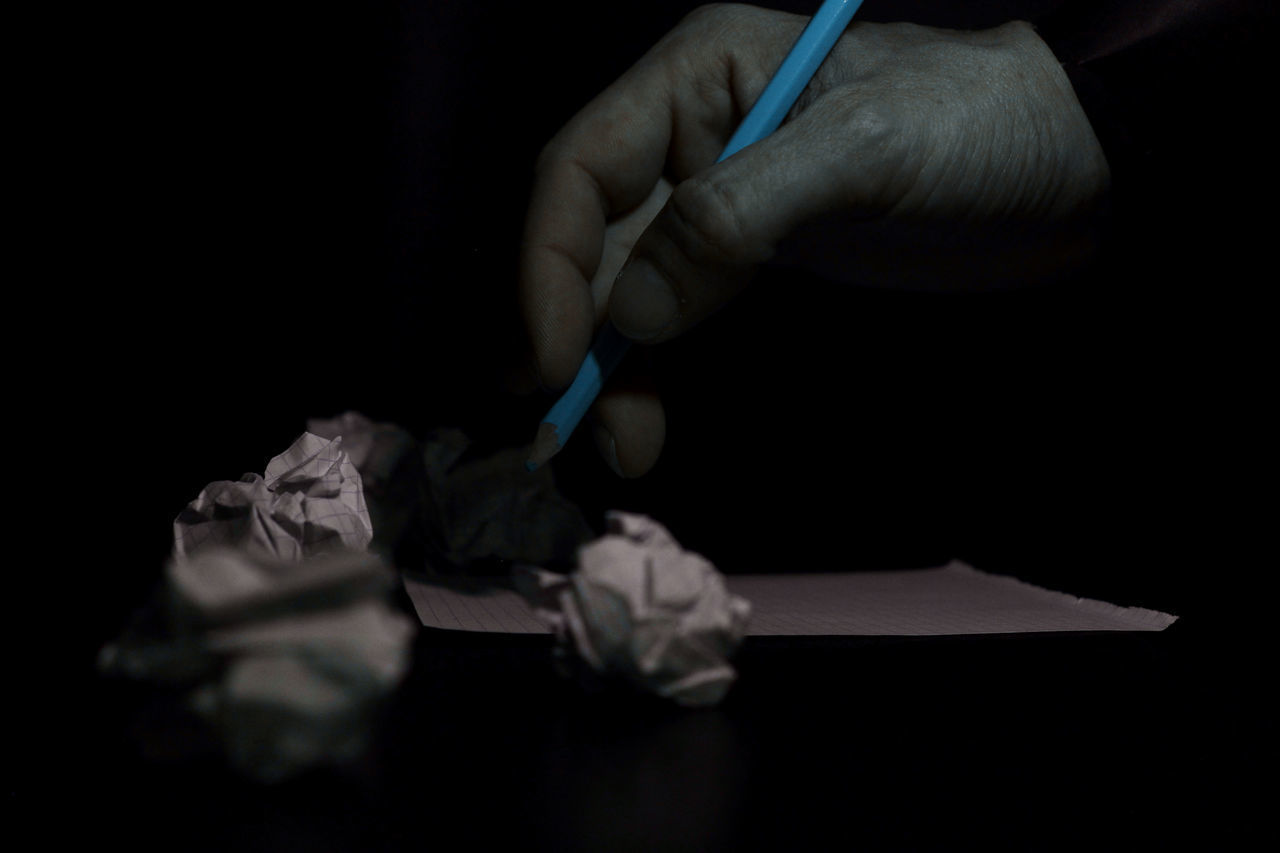 CLOSE-UP OF HUMAN HAND HOLDING PAPER