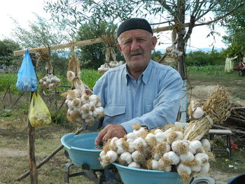 Portrait of senior man selling garlic