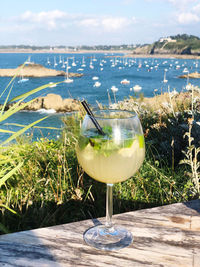 Close-up of wine glass against calm sea