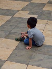 Full length of siblings relaxing on footpath