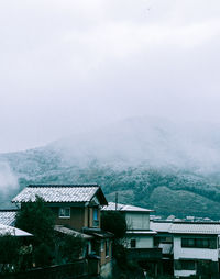 Houses against sky during winter