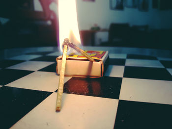 Close-up of illuminated candles on tiled floor