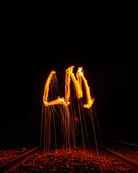 Light painting with alphabets on railroad track at night