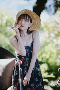 Young woman wearing hat standing outdoors