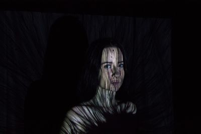 Portrait of young woman with shadow in darkroom