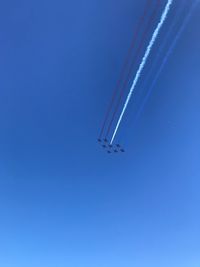 Low angle view of airplane against clear blue sky