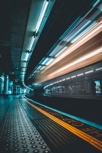 Blurred motion of train at railroad station platform during night