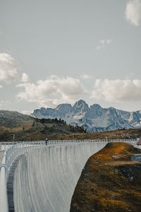 Scenic view of dam and mountains against sky