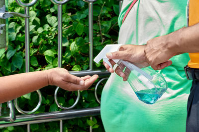 Spray alcohol sanitizer on hand