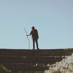 Low angle view of woman standing by railing