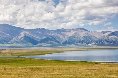 Scenic view of lake by mountains against sky