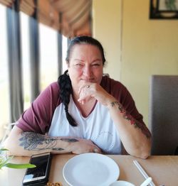 Portrait of a smiling young woman sitting at restaurant