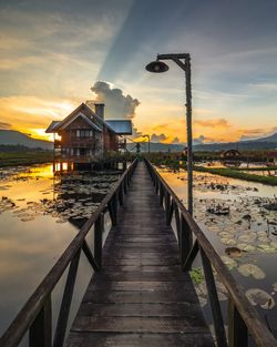 Pier over bridge against sky during sunset