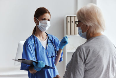 Side view of female doctor examining x-ray at clinic