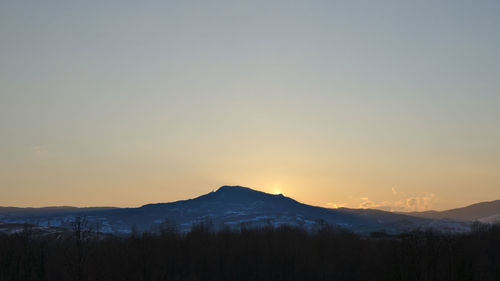 Scenic view of silhouette mountains against sky at sunset