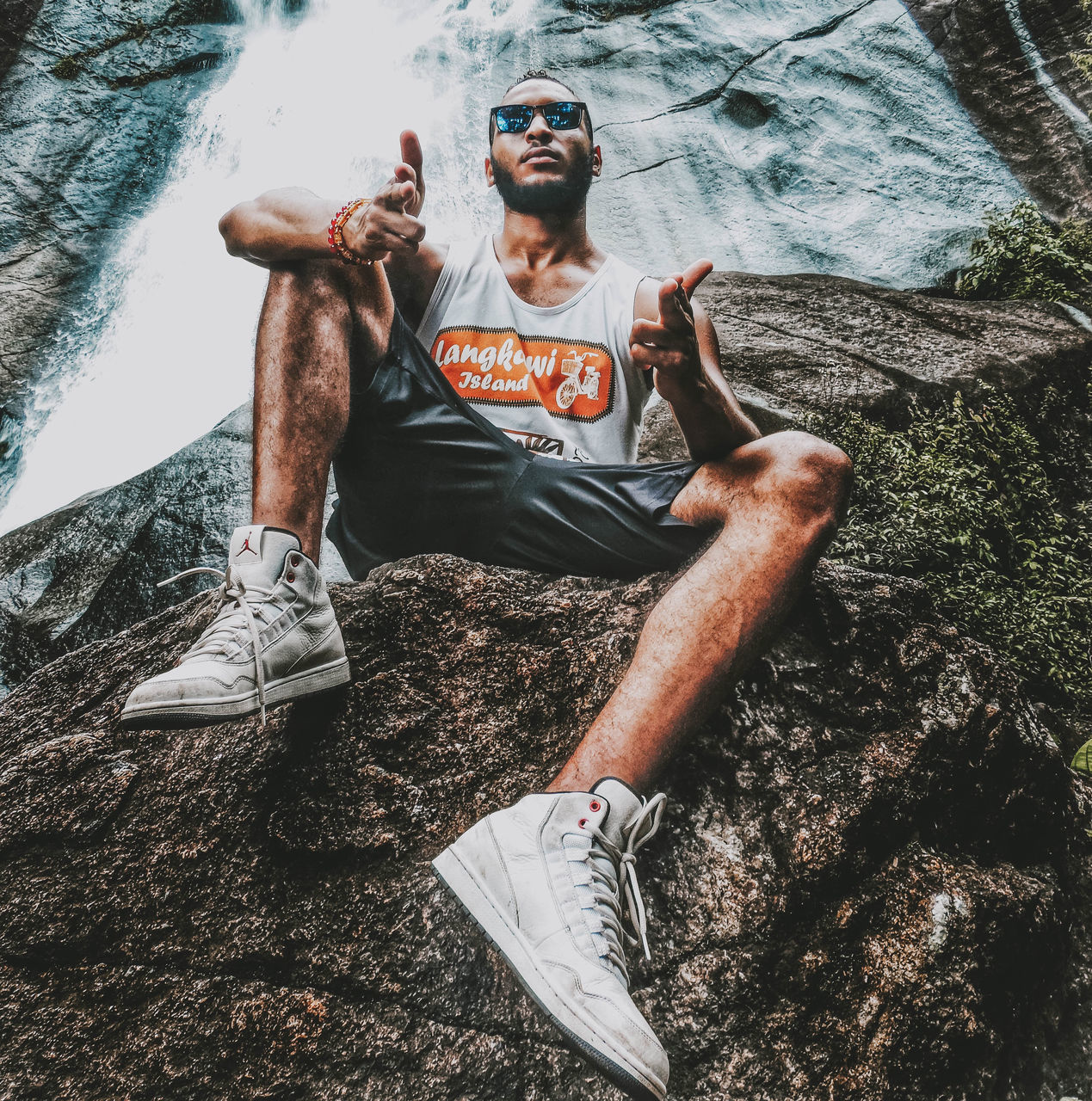 FULL LENGTH PORTRAIT OF YOUNG MAN SITTING AT WATER