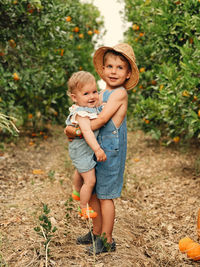 Sister and brother in a orange orchard .summertime between orange trees in portugal