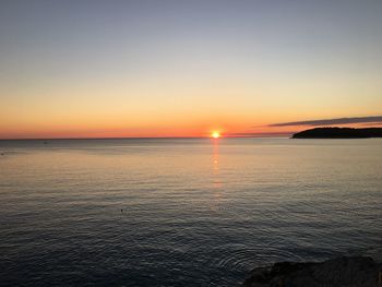 Scenic view of sea against orange sky