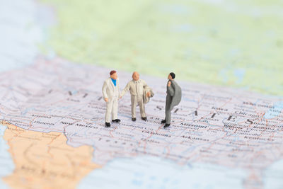 Miniature business people on map with light.