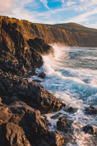 Scenic view of rocks in sea against sky