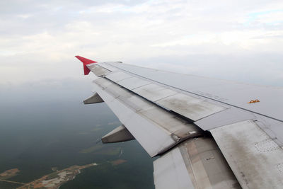 Airplane flying over clouds against sky